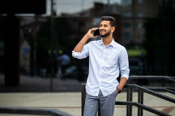 portrait of a young indian businessman talking on the phone