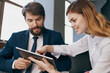 © SHOTPRIME STUDIO - man and woman in business suits looking at the tablet managers professionals