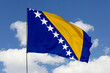 Bosnia and Herzegovina flag isolated on the blue sky background. close up waving flag of Bosnia and Herzegovina. flag symbols of Bosnia and Herzegovina. Concept of Bosnia and Herzegovina.