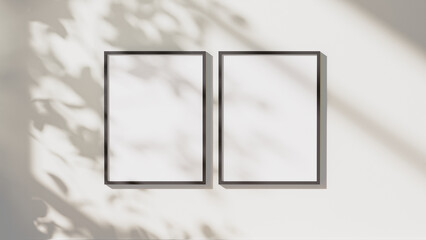 Wall Mural - blank black vertical frames mock up with leaves shadows and sunlight on white wall background, 3d re