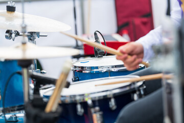 Sticker - Closeup shot of male hands playing drums with the drumsticks in the music studio