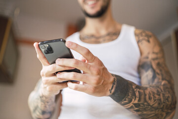 Poster - Shallow focus shot of a Caucasian fit male using his smartphone