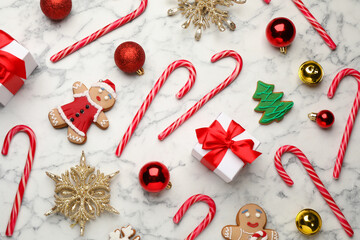 Wall Mural - Flat lay composition with tasty candy canes and Christmas decor on white marble table