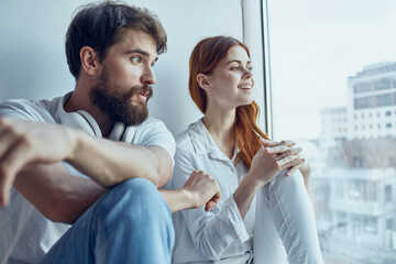 Wall Mural - a young couple chatting near the window romance joy