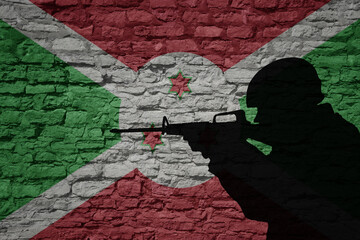 Wall Mural - Soldier silhouette on the old brick wall with flag of burundi country.
