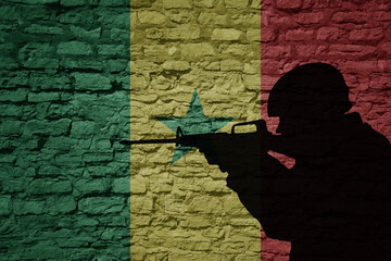 Wall Mural - Soldier silhouette on the old brick wall with flag of senegal country.