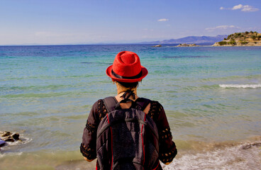 young woman in a red hat on the beach