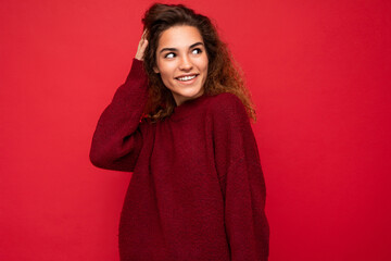 Wall Mural - Shot of attractive happy smiling young woman wearing casual outfit standing isolated over colourful background with empty space looking to the side