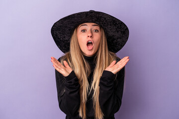 Wall Mural - Young Russian woman disguised as a witch celebrating Halloween isolated on purple background surprised and shocked.