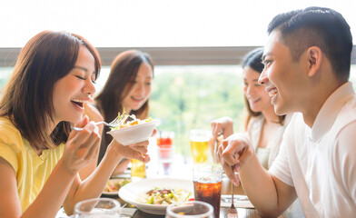 Wall Mural - Happy Young group enjoying food and drink in restaurant