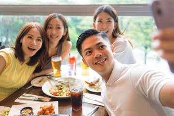 Wall Mural - Happy young  people sitting in  restaurant and taking  selfie