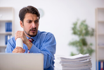 Young male employee unhappy with excessive work in the office