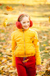 © Анна Молько - girl in a yellow jacket and red pants plays in the park with fallen leaves