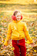 © Анна Молько - girl in a yellow jacket and red pants plays in the park with fallen leaves