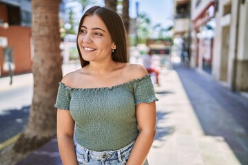 Wall Mural - Young hispanic girl smiling happy standing at the city.