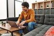 © Krakenimages.com - Young hispanic man having video call using laptop at home.