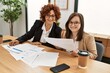 © Krakenimages.com - Group of two women working at the office. Mature woman and down syndrome girl working at inclusive teamwork.