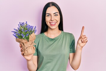 Sticker - Beautiful woman with blue eyes holding lavender plant smiling with an idea or question pointing finger with happy face, number one