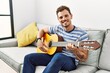 © Krakenimages.com - Young hispanic man smiling confident playing classical guitar at home