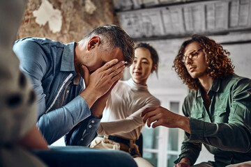 Wall Mural - Young despair man crying during group therapy.