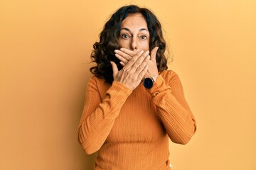 Poster - Middle age hispanic woman wearing casual clothes shocked covering mouth with hands for mistake. secret concept.