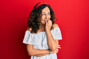 Poster - Middle age hispanic woman wearing casual clothes looking stressed and nervous with hands on mouth biting nails. anxiety problem.