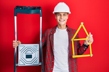 Sticker - Young hispanic man wearing handyman uniform holding construction stairs and house project smiling with a happy and cool smile on face. showing teeth.