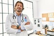 © Krakenimages.com - Middle age caucasian man wearing doctor uniform standing with arms crossed gesture al clinic
