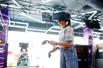 Wall Mural - Girl in vr glasses holds joysticks in her hands