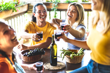 Wall Mural - Happy friends having fun drinking at vineyard patio - Friendship concept with young people enjoying harvest together at farmhouse - Red wine tasting at unique experience outdoor - Warm contrast filter