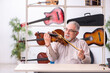 © Elnur - Old male repairman repairing musical instruments at workplace