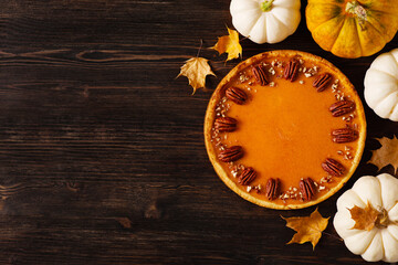 Wall Mural - Traditional pumpkin pie on table, flat lay with pumpkins