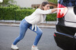 a young woman pushing car
