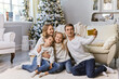 © Inna Vlasova - happy family sitting in living room and taking selfie picture with smartphone at home