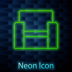 Sticker - Glowing neon line Cinema chair icon isolated on brick wall background. Vector