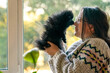© dinastiya - Happy girl with a puppy. A teenage girl stands near the window with a german spitz puppy