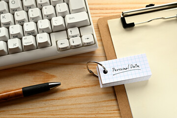 Poster - There is  word book with the word of Personal Data. It's on the desk with a clipboard and a keyboard.
