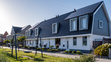 Newly Build Houses With Solar Panels Attached On The Roof Against A Sunny Sky Close Up Of New Building With Black Solar Panels. Zonnepanelen, Zonne Energie, Translation: Solar Panel, Sun Energy