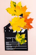 Clapperboard and seasonal autumn maple leaves. Movie clapper board on an autumn background. Top view