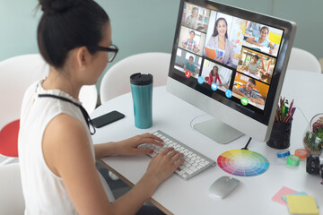 Canvas Print - Asian girl holding computer for video call, with smiling diverse elementary school pupils on screen