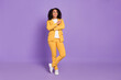 © deagreez - Photo of charming excited woman dressed yellow suit spectacles pointing empty space smiling isolated violet color background