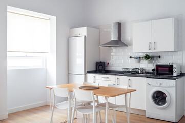 Interior spacious light dining room connected with kitchen in modern contemporary style