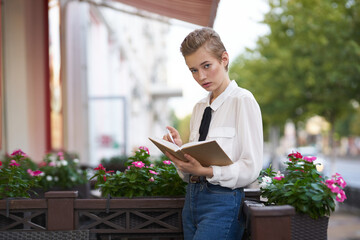 student with a book in his hands outdoors in a summer cafe rest Lifestyle