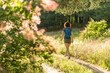 © mihakonceptcorn - Young woman walks along a forest path, rear view.