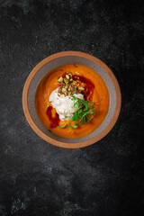 Sticker - Pumpkin cream soup mashed with spices and a sprig of peas on a dark stone table