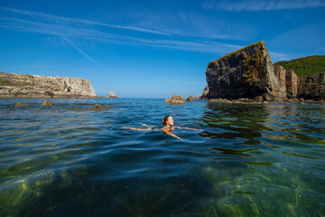 Happy woman swimming in a beautiful beach