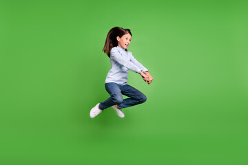 Poster - Photo of beautiful funky schoolgirl wear blue turtleneck jumping high riding horse smiling isolated green color background