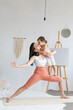 © Вадим Каштанов - Little daughter helps mom practice yoga. Happy and healthy family.