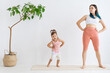 © Вадим Каштанов - Mom and daughter doing warm-up home on fitness mat. Concept of healthy and friendly family.