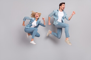 Poster - Full body profile side photo of young couple happy positive smile jump run hurry isolated over grey color background